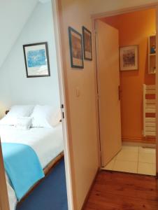 Schlafzimmer mit einem Bett und einer Tür, die zu einem Bad führt in der Unterkunft Doubs Séjour - Maison de vacances in Verdun-sur-le-Doubs