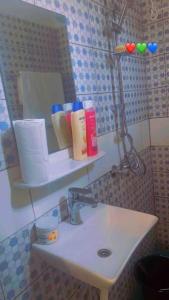 a bathroom with a sink and a mirror at La Perle du Sahel avec clé personnel du portail in Niamey