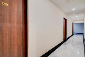 a hallway with a wooden door and a tile floor at Townhouse 1343Oriental INN in Chennai