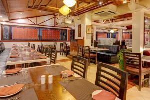 a dining room with wooden tables and chairs at Townhouse 1343Oriental INN in Chennai