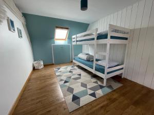 a bedroom with two bunk beds and a checkered floor at Maison Mboa in Fouesnant