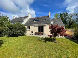 a house with a picnic table in a yard at Maison Mboa in Fouesnant