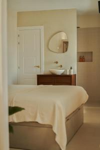 a bathroom with a bed and a sink and a mirror at Casa Uva - Boutique Stay in Vejer de la Frontera