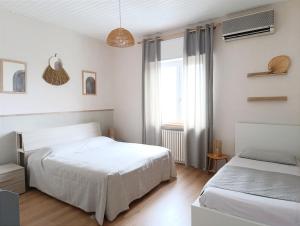 una camera bianca con due letti e una finestra di Kasakiwi Apartment a Vicenza