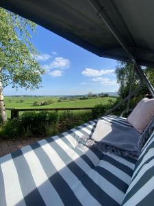 a bed in a tent with a view of a field at Betula Views Studio in Newent