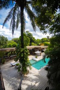 een resort met een zwembad en een palmboom bij Santa Fe Casas Hotel Trancoso in Trancoso