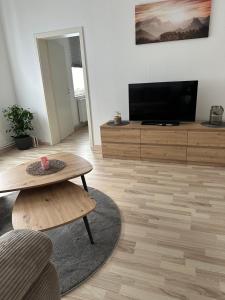 a living room with a television and a coffee table at Ferienwohnung Sohnreystrasse in Holzminden