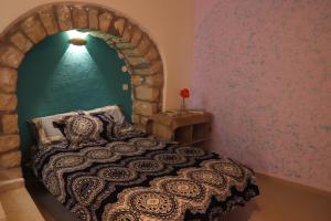 a bedroom with a bed in a brick wall at The Essence in Safed