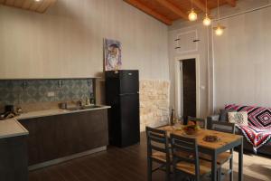 a kitchen with a table and a refrigerator in a kitchen at The Essence in Safed