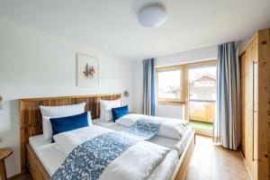 a bedroom with two beds and a large window at Haus Tannberg in Riezlern