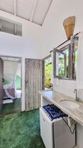 a bathroom with a sink and a room with a bed at Vila Pitanga Trancoso in Trancoso