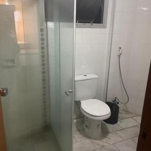 a bathroom with a toilet and a glass shower at Prestige Manaus Hotel in Manaus