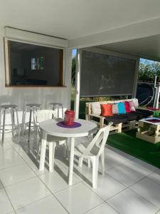 ル・ロベールにあるVilla KLYTANLYのベッド付きのポーチ(テーブル、椅子付)