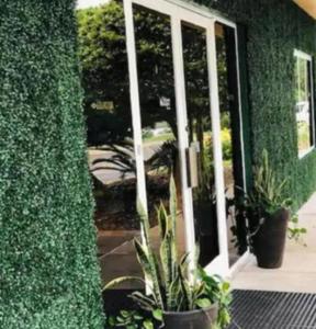 eine offene Tür mit Topfpflanzen vor einem Gebäude in der Unterkunft Quality Inn At Eglin AFB in Niceville