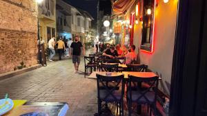 a group of people sitting at tables outside a restaurant at Callisto Pub & Kitchen & Hotel in Antalya