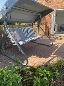 una silla bajo un cenador en un patio en Betula Views Studio, en Newent
