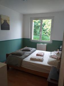 Schlafzimmer mit einem großen Bett und einem Fenster in der Unterkunft Maison de 4 chambres avec jardin clos et wifi a Villers sous Foucarmont in Villers-sous-Foucarmont