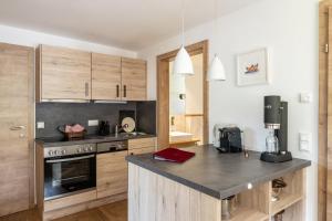 eine Küche mit Holzschränken und einer Arbeitsplatte in der Unterkunft Haus Tannberg in Riezlern
