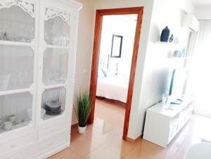 sala de estar con armario blanco y espejo en Apartamento Con Vistas en Nerja, en Nerja
