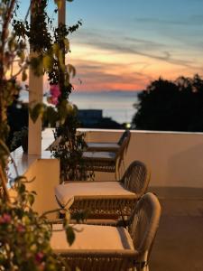 four chairs and tables on a balcony at sunset at Dimora Storica Villa Pasquale Capri in Capri