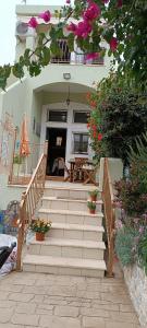 Una escalera que conduce a una casa con flores. en Seaside Apartments 1, en Emborios