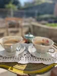 dwie filiżanki kawy siedzące na stole w obiekcie Villa Pasquale Capri w mieście Capri