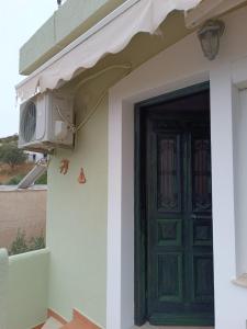 a green door on a house with a balcony at Seaside Apartments 1 in Emborios