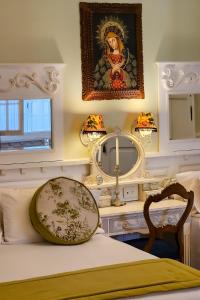 een slaapkamer met een bed met een spiegel en een tafel bij Villa Vicuña Hotel Boutique in Salta