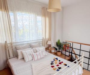 a white bed in a bedroom with a window at Casa Verde Houses in Kos