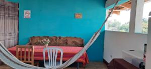 Habitación con una hamaca alrededor de una mesa con una pared azul. en Hostal Dulces Sueños en Panajachel