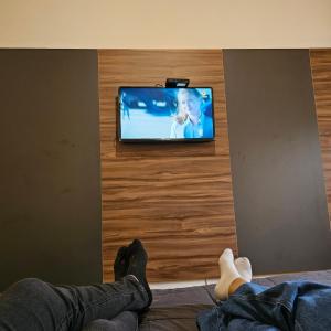 una persona tirada en el suelo viendo una televisión en Hotel Tafí en Tafí del Valle