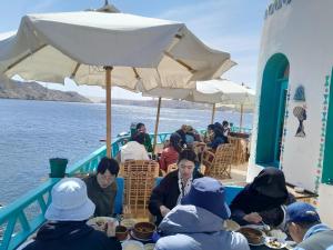 un grupo de personas sentadas en una mesa en un barco en Miskaa Nubian House en Tingar