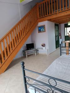 1 dormitorio con escalera, cama y escritorio en Seaside Apartments 1, en Emborios
