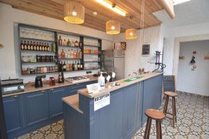 a bar with blue cabinets and stools in a room at Alaçatı Disa in Alaçatı