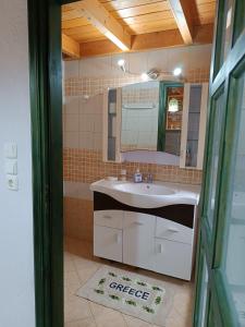 uma casa de banho com um lavatório e um espelho em Seaside Apartments 1 em Emborios