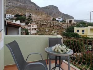 a balcony with two chairs and a table with flowers at Seaside Apartments 1 in Emborios
