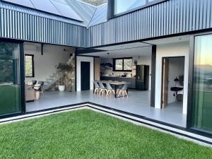 a house with a patio with a table and grass at The Unbound - Escape the Ordinary in Romansrivier