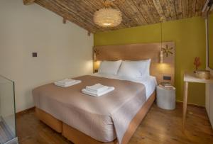 een slaapkamer met een groot bed en 2 handdoeken bij Driades Luxury Apts by Estia in Chersonissos