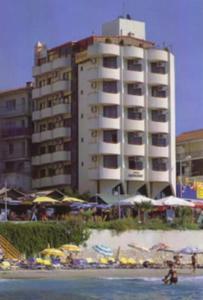 Sergent Hotel في كوساداسي: مبنى كبير على الشاطئ بالقرب من المحيط
