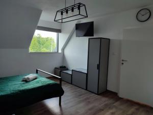 LeszczewekにあるSiedlisko Bogdankaのベッドルーム1室(ベッド1台、キャビネット、時計付)
