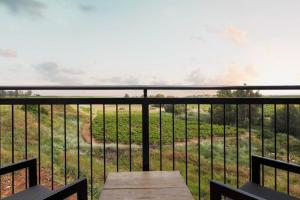 a table on a balcony with a view of a field at Yarden Estate Boutique Hotel in Yesod Hamaala