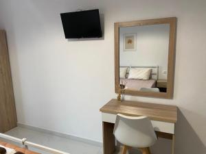 Habitación con espejo, escritorio y cama. en Exarhos Apartment, en Paralia Katerinis