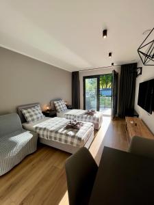 Apartamenty Sopot19 في سوبوت: غرفة معيشة بها سريرين وأريكة