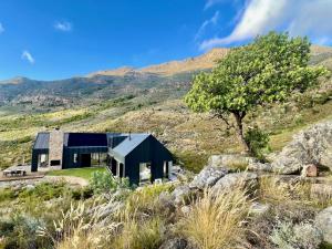a house on a hill with mountains in the background at The Unbound - Escape the Ordinary in Romansrivier