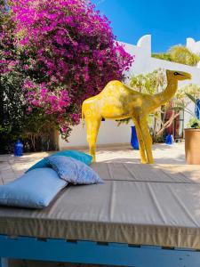 una estatua de un caballo de oro sentada en la parte superior de una cama en L' Ecrin de Mogador Essaouira, en Ounara