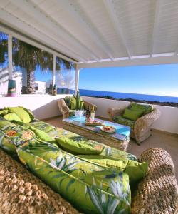 een balkon met een bank en een tafel en de oceaan bij Villa Sunset Paradise with panoramic sea view, first line, sunsets in Playa Blanca