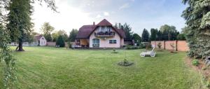 a house with a lawn in front of it at Liliána apartman in Balatonberény