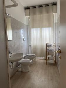 a bathroom with two toilets and a sink at Albergo AQUILA in Lazise