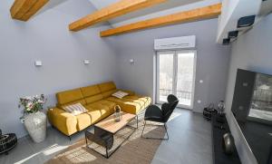 sala de estar con sofá amarillo y TV en ELYSIUM Townhouse Imotski, en Imotski