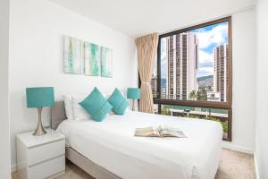 a bedroom with a white bed and a large window at Newly Renovated 2 Bedroom Condo, 1 Block to Waikiki Beach, Free Parking in Honolulu +77 photos